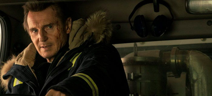 Liam Neeson dirigindo um caminhão
