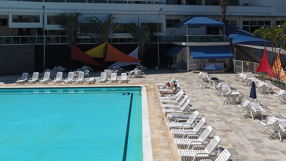 área da piscina com cadeiras no entorno